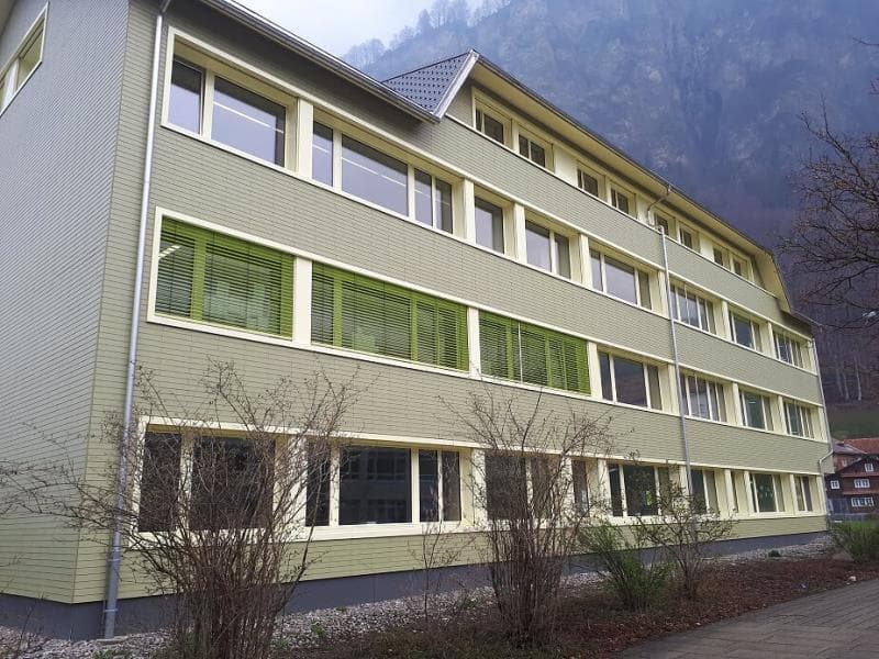 Schulhaus mit Eternitfassade grün